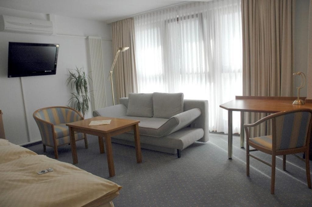 Drawing room with double bed at Parkhotel Goldlinde, Bodenwerder.